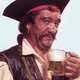 Man dressed as pirate holds up mug of beer